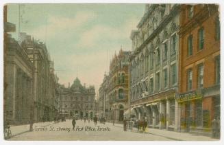 Colorized photograph of a city street with tall building on either side. Large, Second Empire s…