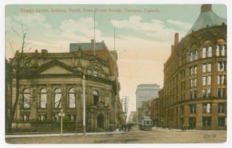 Sepia toned photograph of an a rococo style building on the left and an early skyscraper buildi…