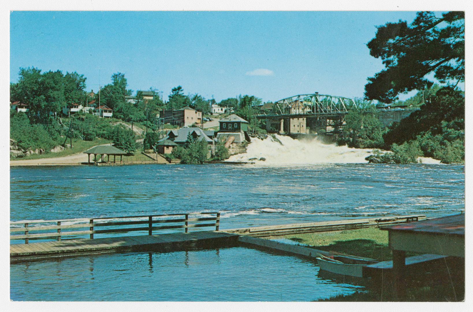 Color photograph of a bridge over a waterfall.