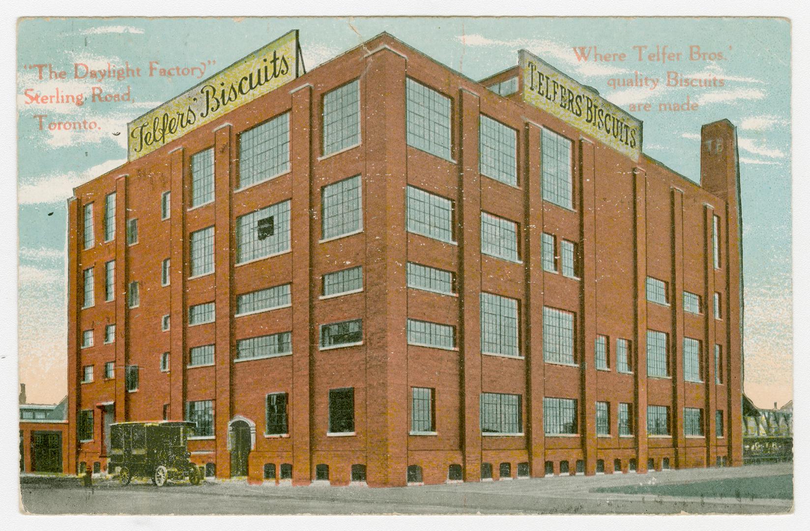 Picture of a five storey factory building on a street corner. 