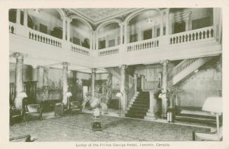 Black and White photograph of a lavish hotel lobby. Staircase and balcony.