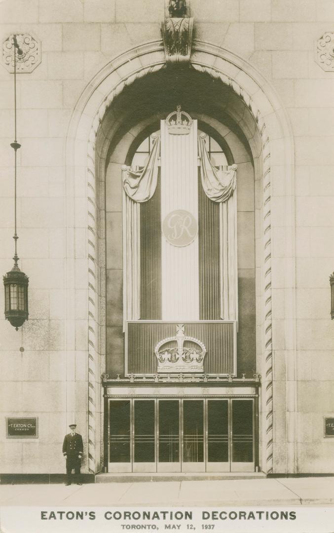 Picture of front entrance of store decorated with coronation flags and banners.