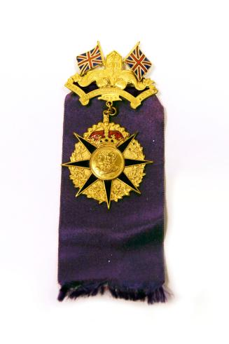 A metal pin attached to a purple ribbon. The medal shows the profiles of the Duke and Duchess o…