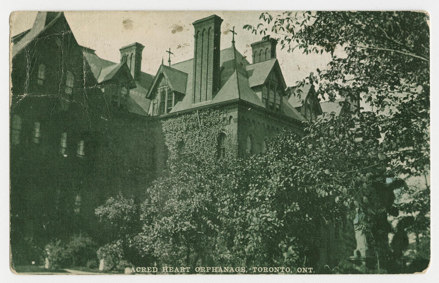 Picture of a large Victorian building with trees in front. 