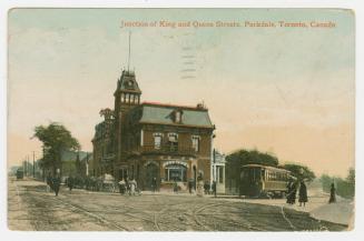 Picture of a junction with hotel and streetcar tracks and streetcar. 