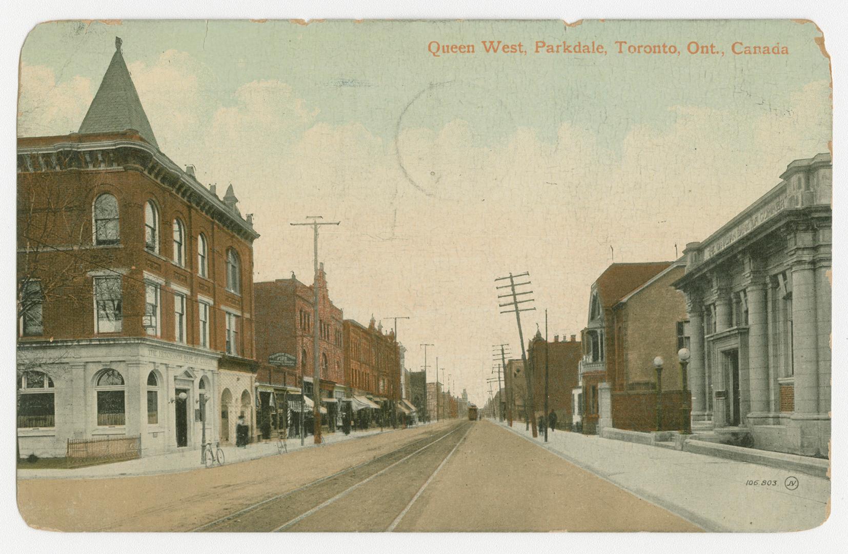 Picture of a street with streetcar line down the middle and buildings on both sides.