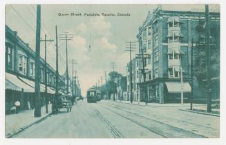 Picture of a street with streetcar line down the middle and buildings on both sides.