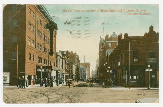 Picture of busy intersection with theatre building on left. 