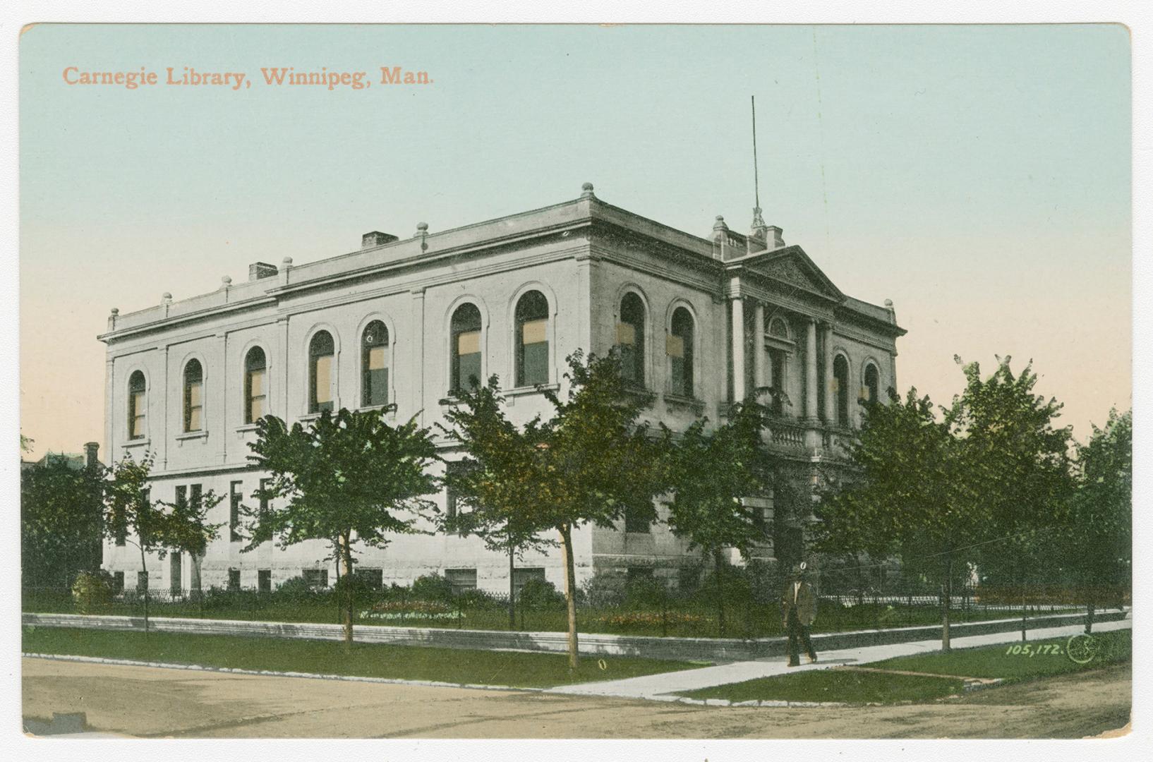 Picture of two storey library building with trees and lawn out front. 