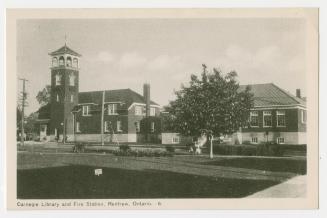 Picture of fire station with tower and library building. 