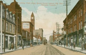 Picture of a street with City Hall tower on left and buildings on both sides and streetcar in m…