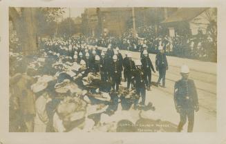 Black and white photograph of soldiers in dress uniform on parade.