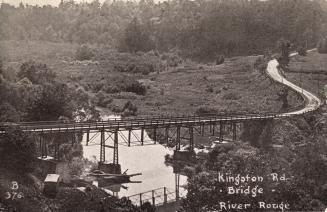 Picture of a bridge over a river surrounded by trees. 