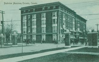 Blue-toned postcard depicting a photo of the exterior of an apartment building, with caption, "…