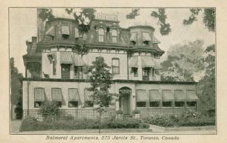 B/W postcard depicting a photo of the frontal exterior of an apartment building, with caption, …