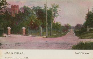 Colour postcard depicting a crossroads intersection with a large house in the distance, with ca…