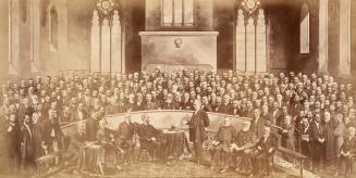 A composite photograph of a conference meeting taking place in a church, with several dozen men…