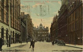 Colorized photograph of a city street with tall building on either side. Large, Second Empire s…