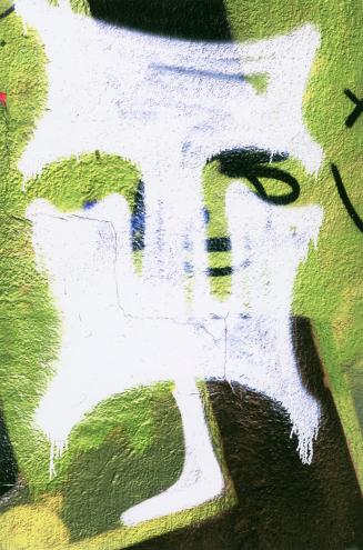 A close-up photograph of a surface covered in posters and graffiti. Portions of posters, some o ...