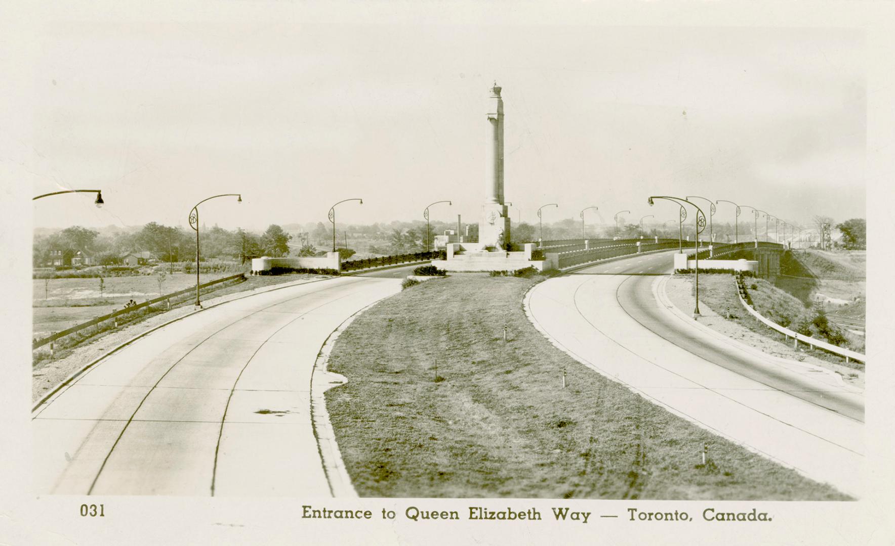 Black and white photograph of a large, monument with lions at it's base in the middle of a six …