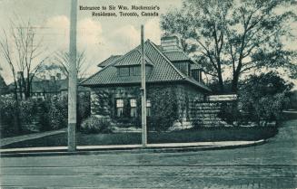 Faded blue-toned postcard depicting an image of the exterior of a home which is actually a gate…