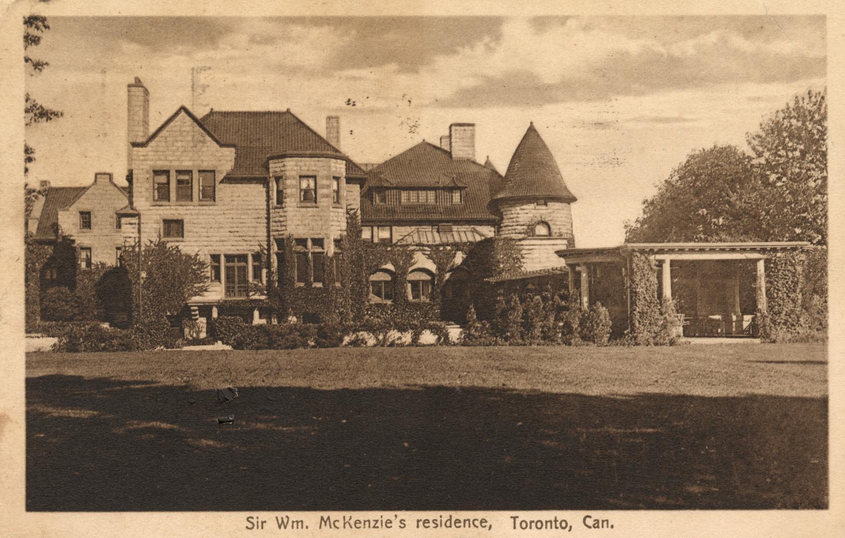 Sepia-toned postcard depicting an image of the frontal exterior of a large home. The caption at…