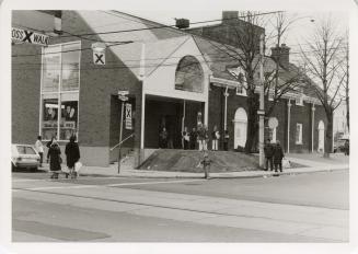 Photo of library building and people outside. 