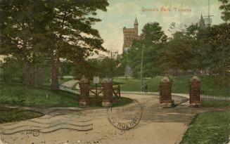 Brick gates on a roadway in front of trees and a large collegiate building. 