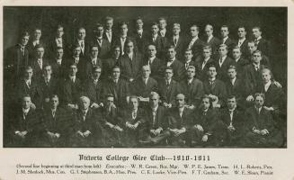 Black and white photograph of a large group of men in gowns.