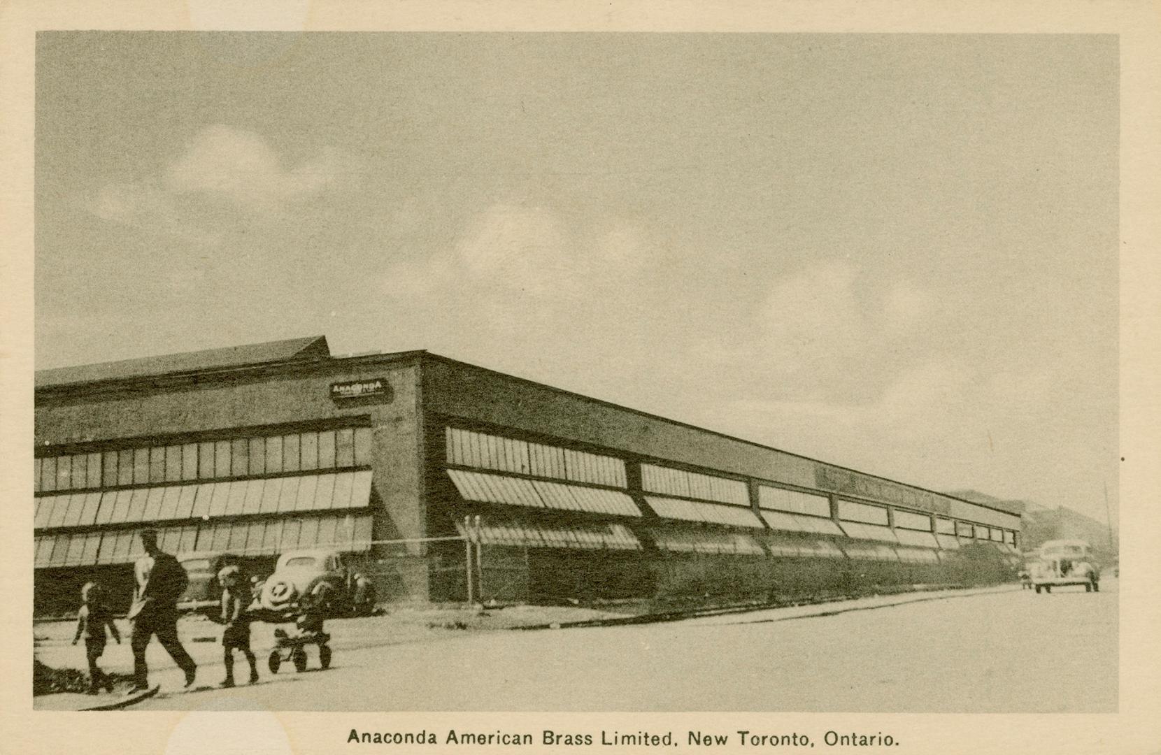 Sepia-toned photo postcard depicting a large warehouse building with many windows. Caption stat…