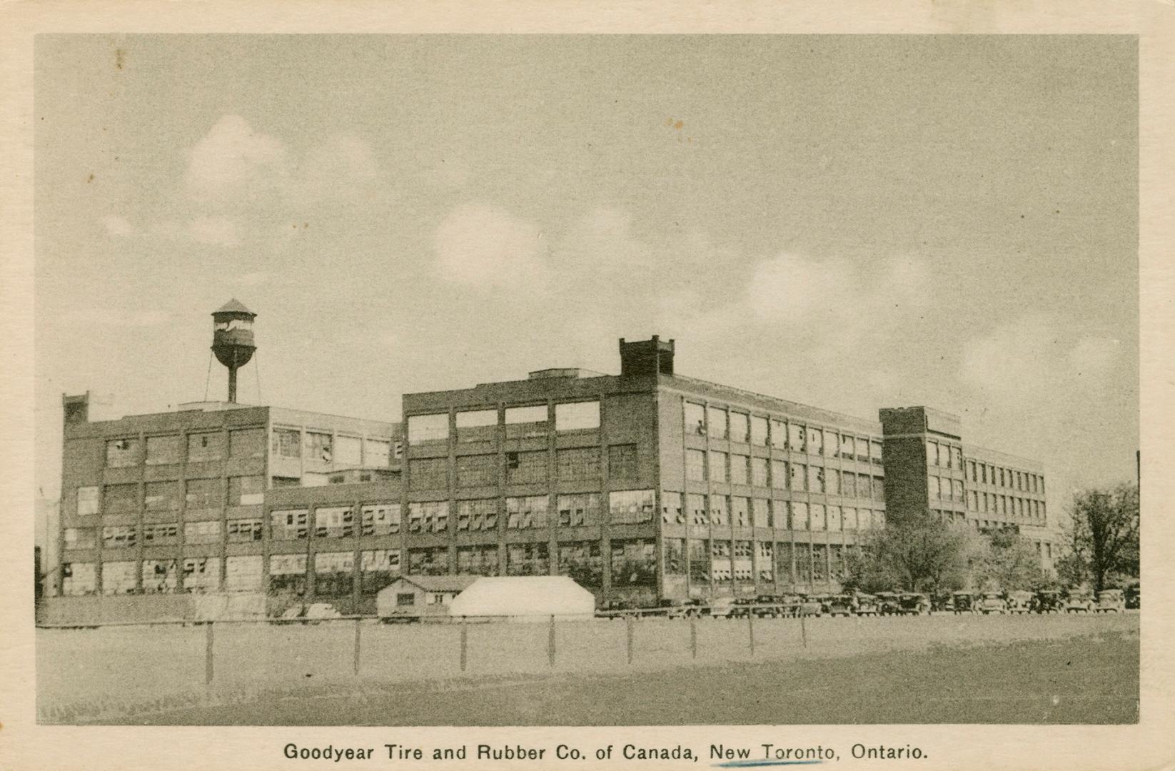 Sepia-toned photo postcard depicting a large warehouse building with many windows. Caption stat…