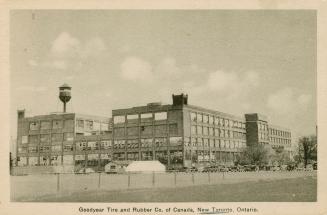 Sepia-toned photo postcard depicting a large warehouse building with many windows. Caption stat…