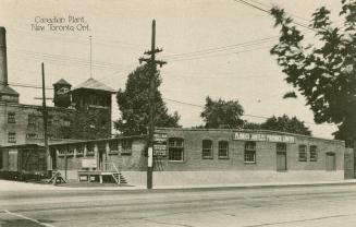 Black/white photo postcard depicting a warehouse building with the sign "Plibrico Jointless Fir…