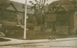 Black and white photograph of town houses in a mock-Tudor style,