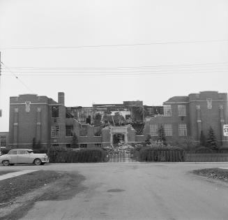 A photograph of a large school displaying damage from a fire. The middle of the building and th ...