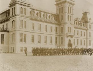 A photograph of a four-story building with windows evenly placed along both sides visible. Ther…