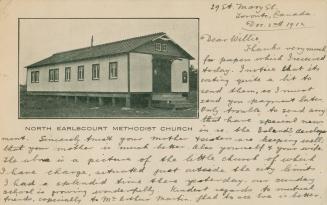 Black and white photograph of a one story frame building.