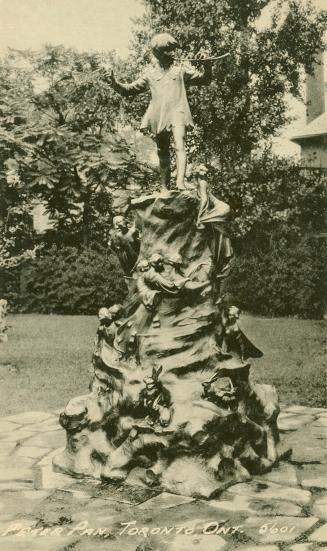 Black and white photograph of a bronze stature of a small bow blowing a pipe.