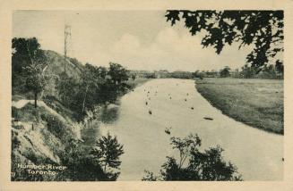 Black and white photograph of a narrow river running through a rocky field.