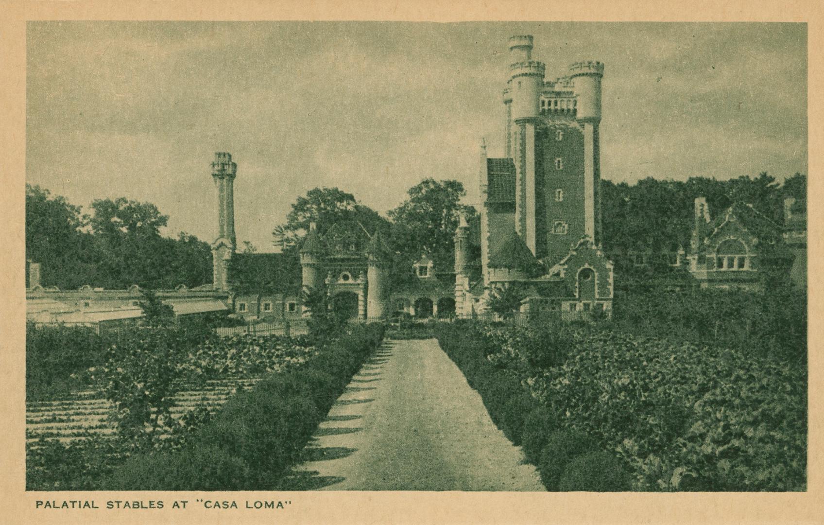 Black and white picture of a a road leading up to outbuildings of a castle.