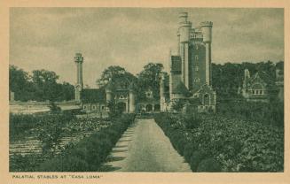 Black and white picture of a a road leading up to outbuildings of a castle.