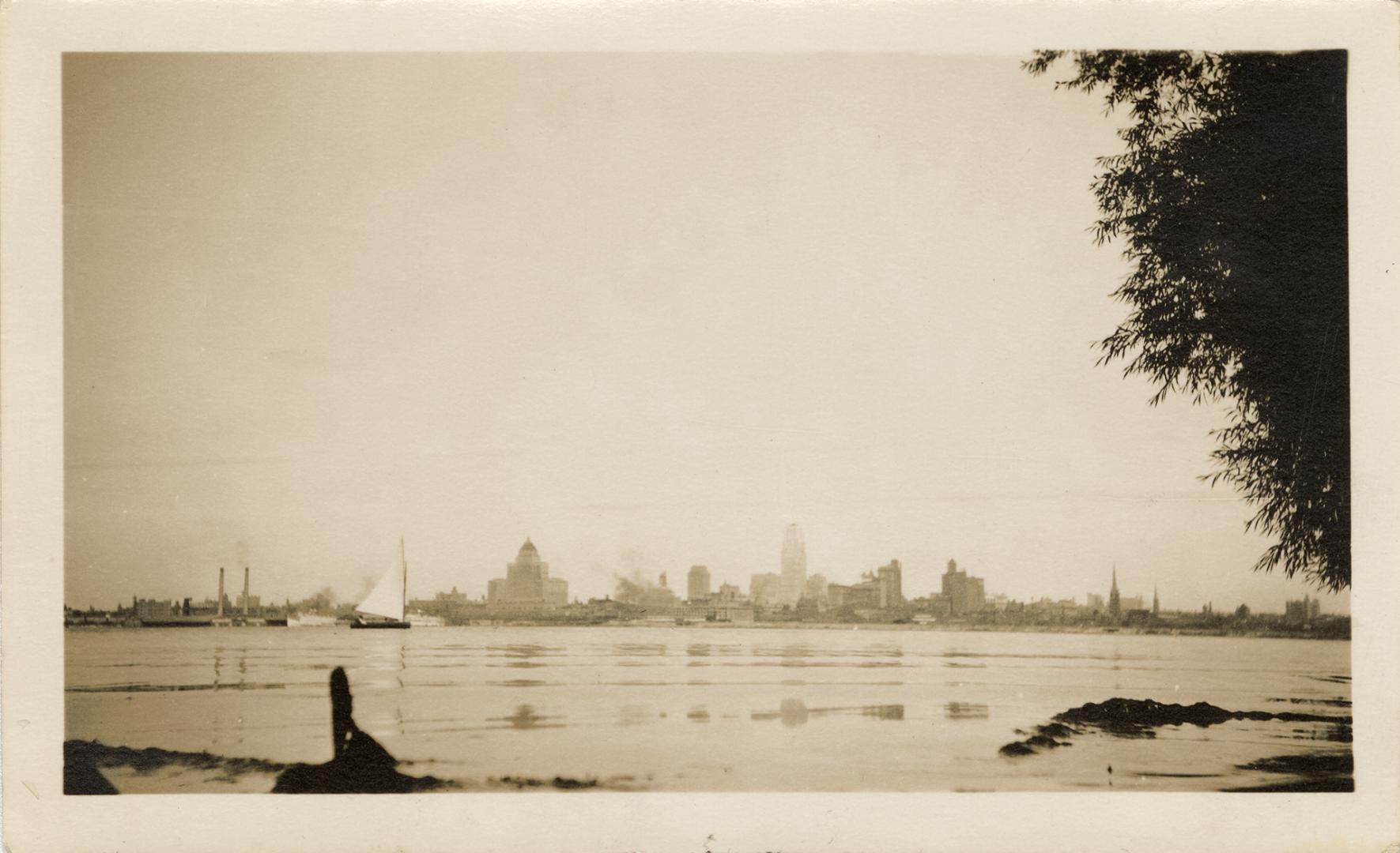 A photograph of a city skyline, with many tall buildings and skyscrapers visible on the far sid…