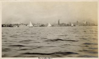 A photograph of a city skyline, taken from across or on a large body of water. Buildings and sm…