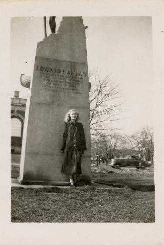 A photograph of a person standing in front of a monument with the words "EDWARD HANLAN" etched …