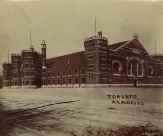 A photograph of a large stone building in a Romanesque Revival style, with towers and castellat…