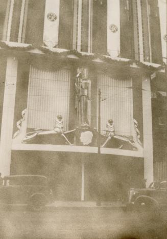 A photograph of the entranceway to a store decorated with bunting and sculptures. The bunting i…