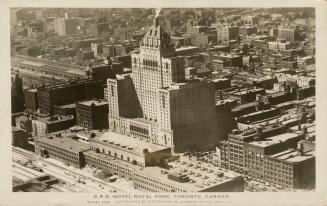 Black and white photograph taken from the air of a chateauesque style building in the center of…