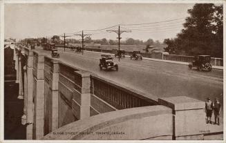 Black and white photograph of cars crossing a concrete and steel bridge.