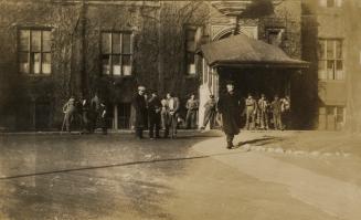 A photograph of the entranceway to a hospital. There is a paved roundabout driveway in front of…