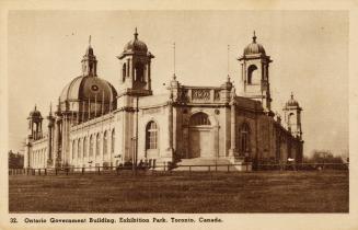 Sepia toned photograph of a one story triangular building in the Beaux Arts style.